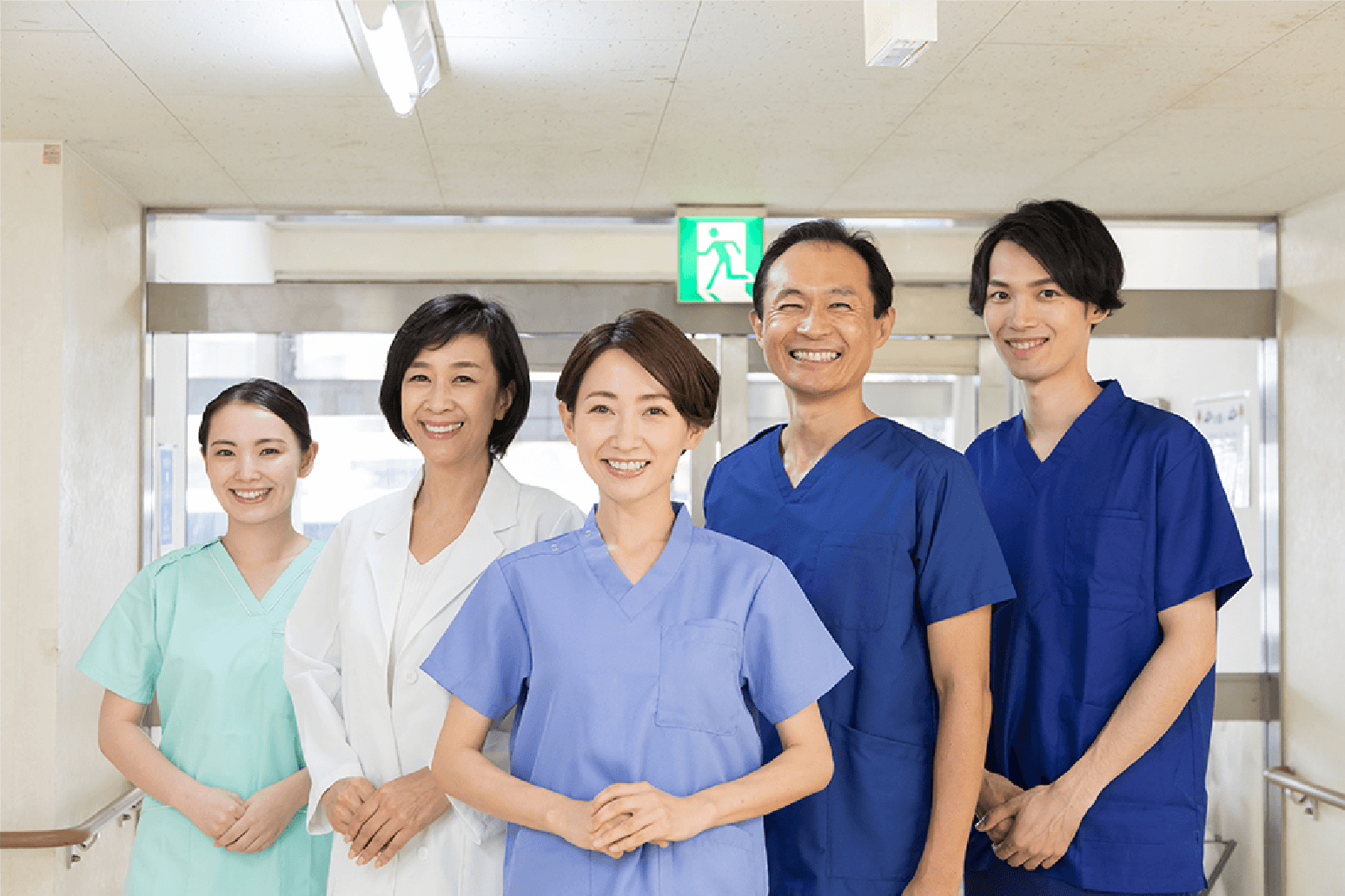 笑顔で並ぶ医療スタッフ5名（看護師と医師）が写っています